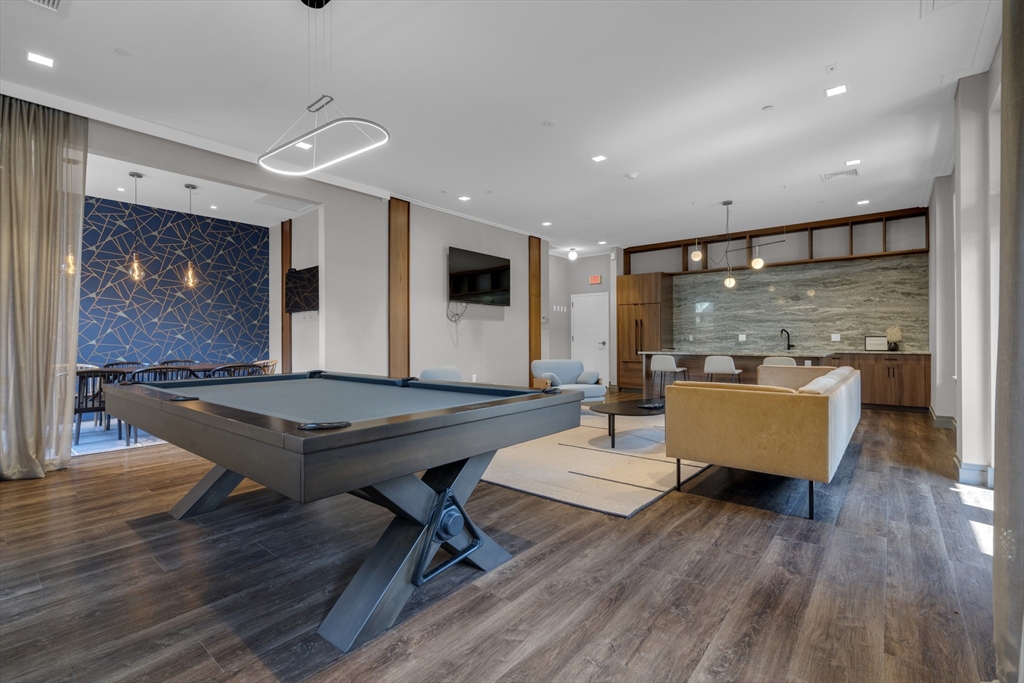 70 Leo M Birmingham Parkway, Unit U307 Boston, MA 02135 - Photo 28 of 35 a living room with furniture a table and wooden floor