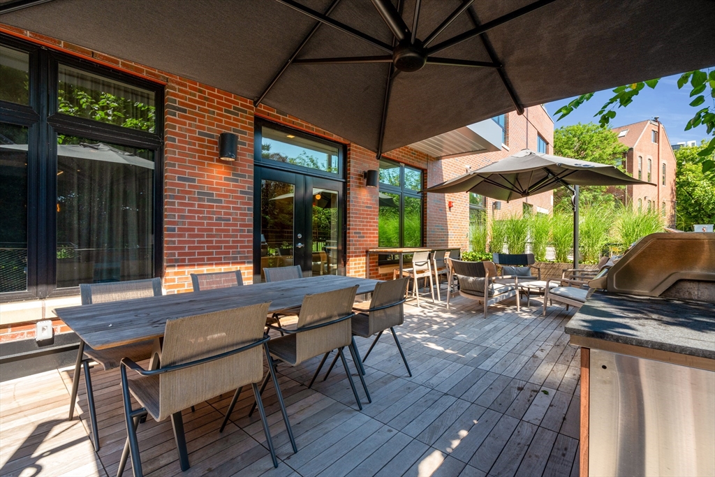 70 Leo M Birmingham Parkway, Unit U307 Boston, MA 02135 - Photo 31 of 35 a view of a patio with table and chairs under an umbrella