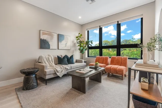 a living room with furniture and a floor to ceiling window