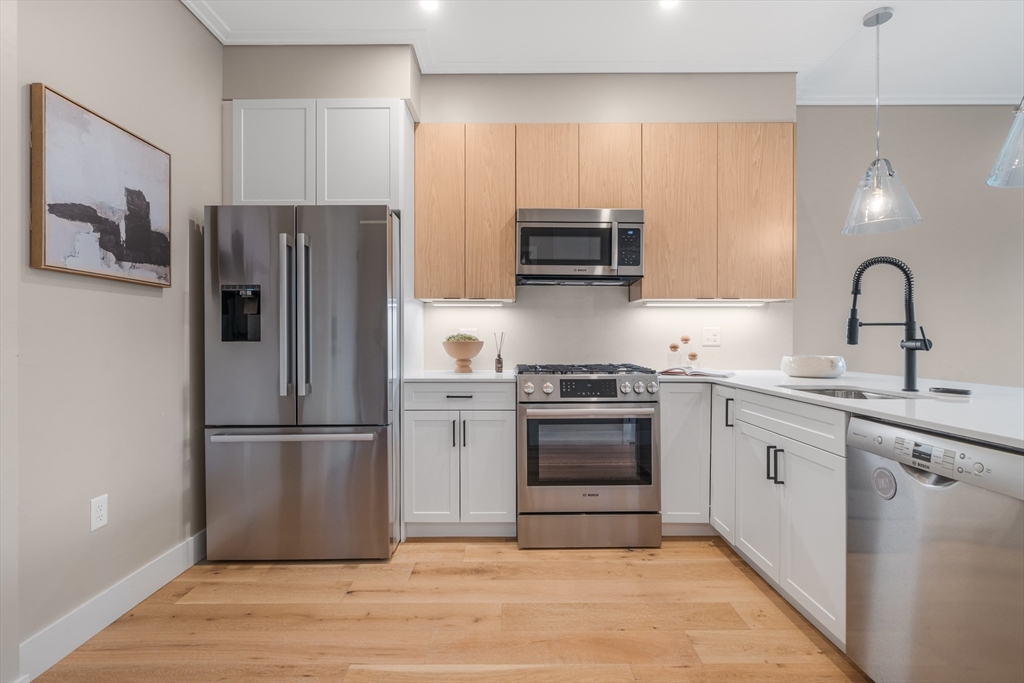70 Leo M Birmingham Parkway, Unit U307 Boston, MA 02135 - Photo 10 of 35 a kitchen with stainless steel appliances granite countertop a refrigerator stove and sink