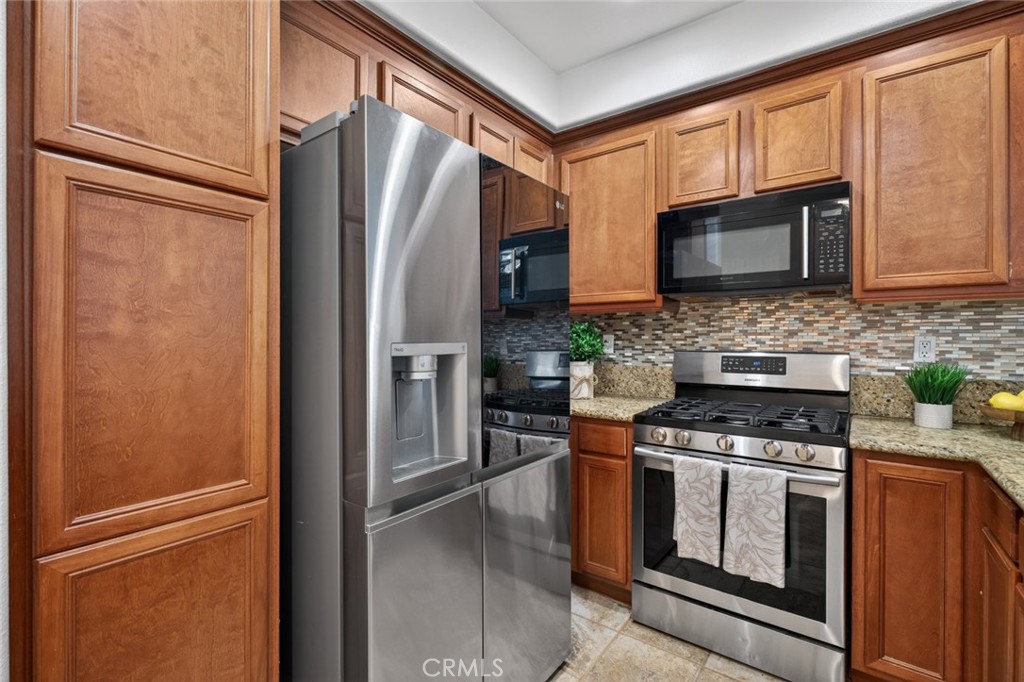 14 Valmont Way Ladera Ranch, CA 92694 - Photo 11 of 39 a kitchen with stainless steel appliances granite countertop a refrigerator stove and microwave
