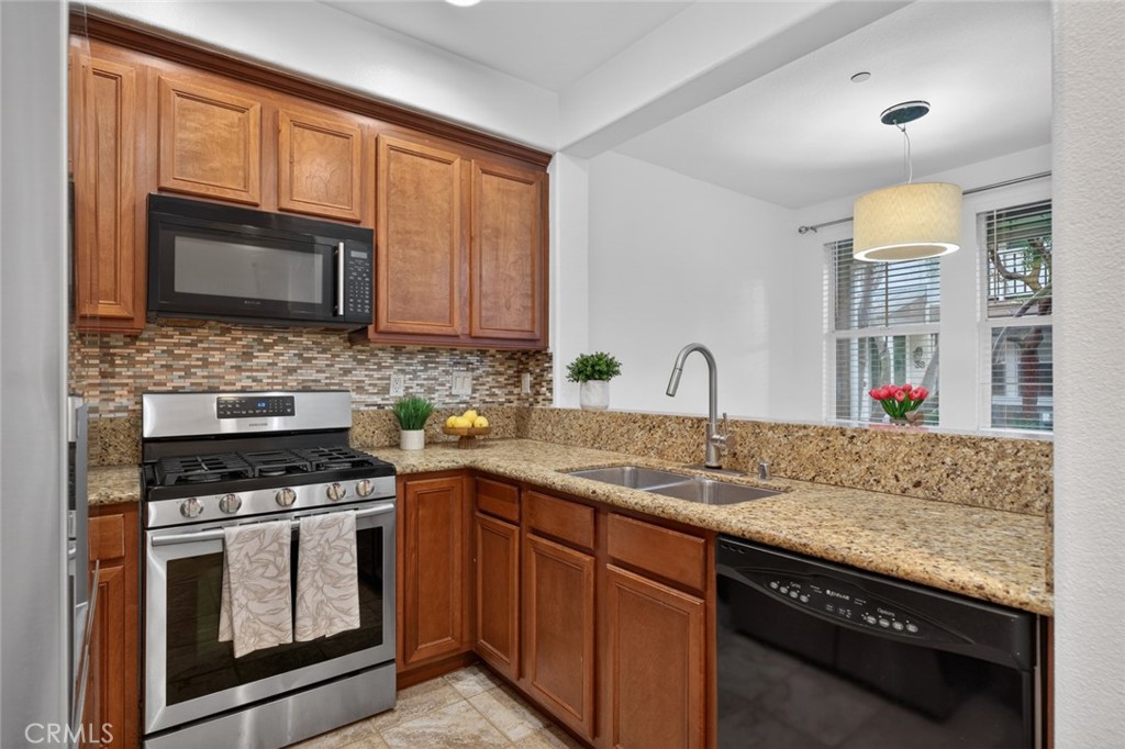 14 Valmont Way Ladera Ranch, CA 92694 - Photo 12 of 39 a kitchen with granite countertop a sink stove and cabinets