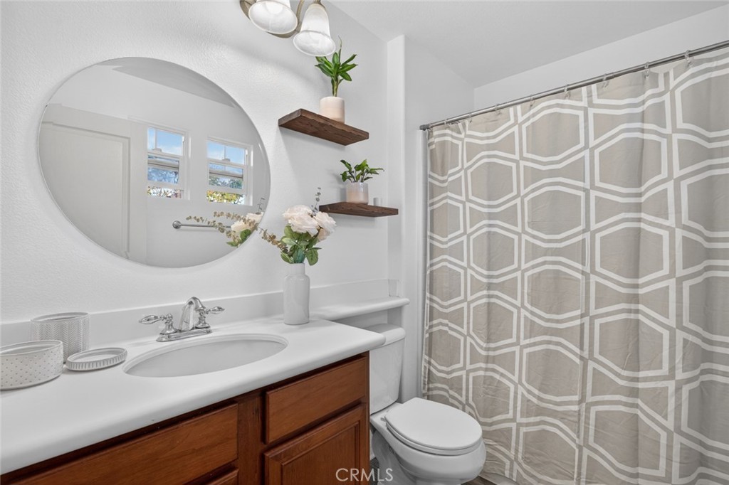 14 Valmont Way Ladera Ranch, CA 92694 - Photo 31 of 39 a bathroom with a granite countertop sink a toilet and a mirror