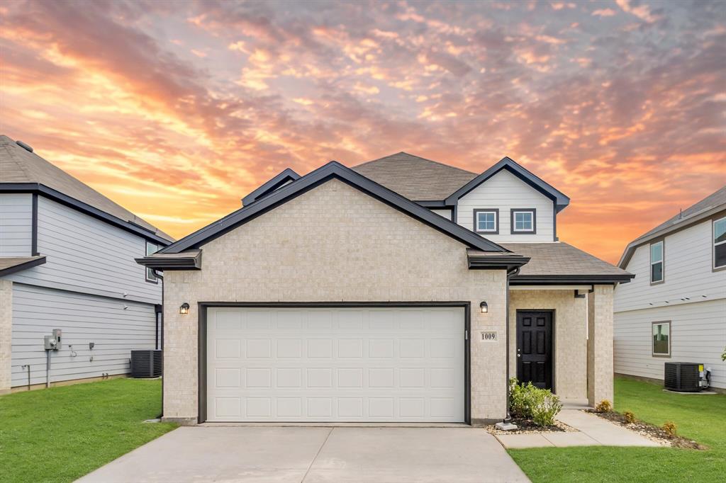 a view of a white house next to a yard with potted plants