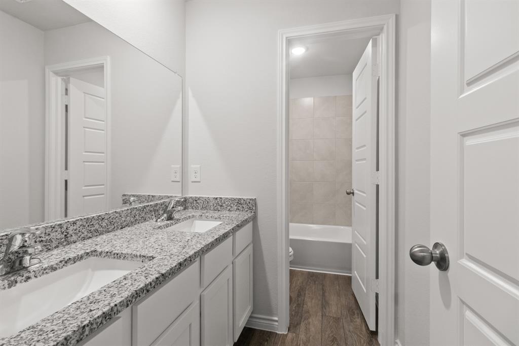 1009 Wind Drift Way Fort Worth, TX 76131 - Photo 14 of 40 a bathroom with a granite countertop sink a mirror and a bathtub