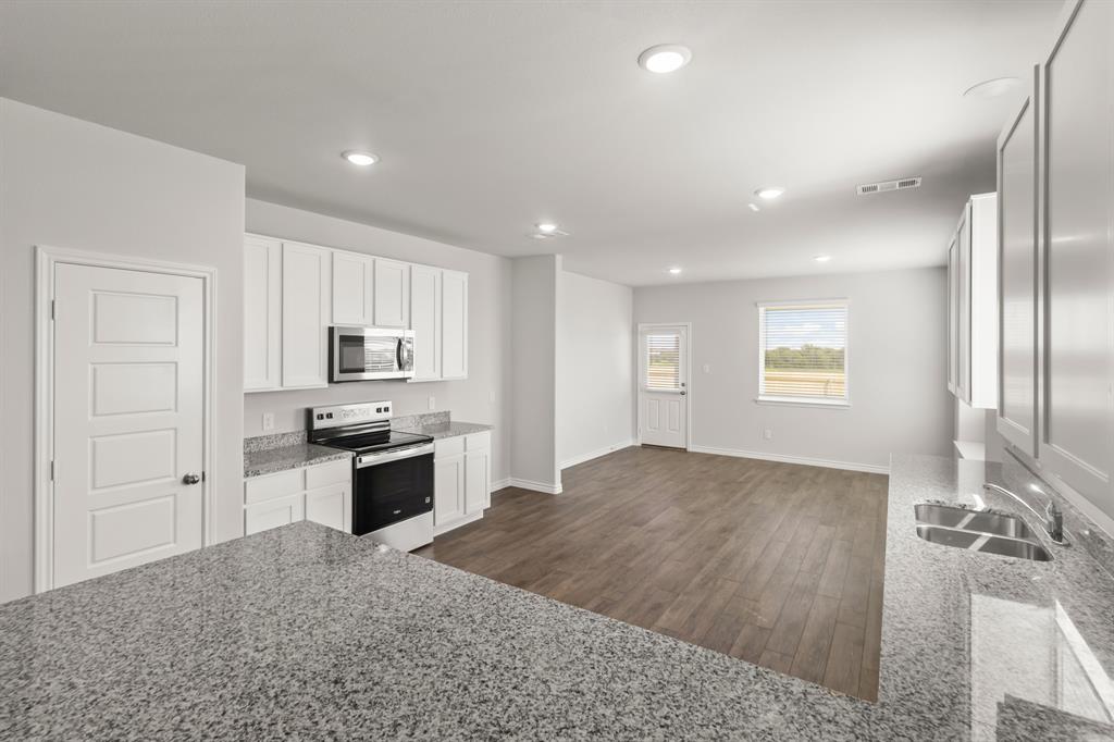 1009 Wind Drift Way Fort Worth, TX 76131 - Photo 2 of 40 a large kitchen with kitchen island a sink stainless steel appliances and cabinets