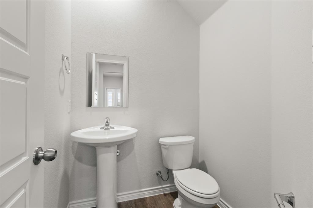 1009 Wind Drift Way Fort Worth, TX 76131 - Photo 5 of 40 a bathroom with a toilet sink and mirror