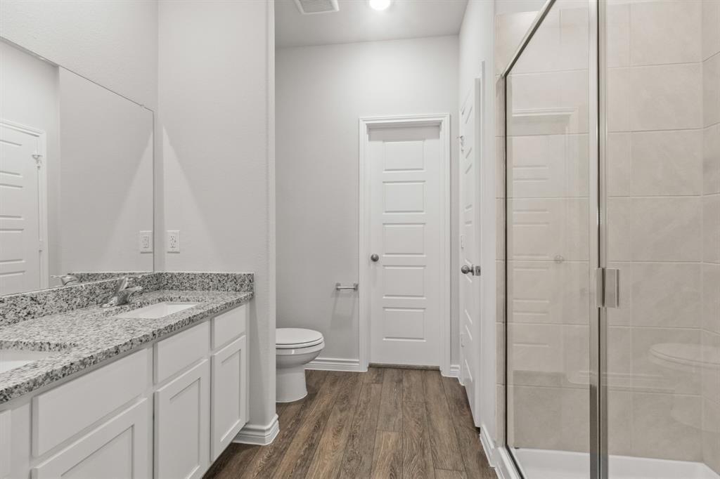 1009 Wind Drift Way Fort Worth, TX 76131 - Photo 8 of 40 a bathroom with a granite countertop sink toilet and shower