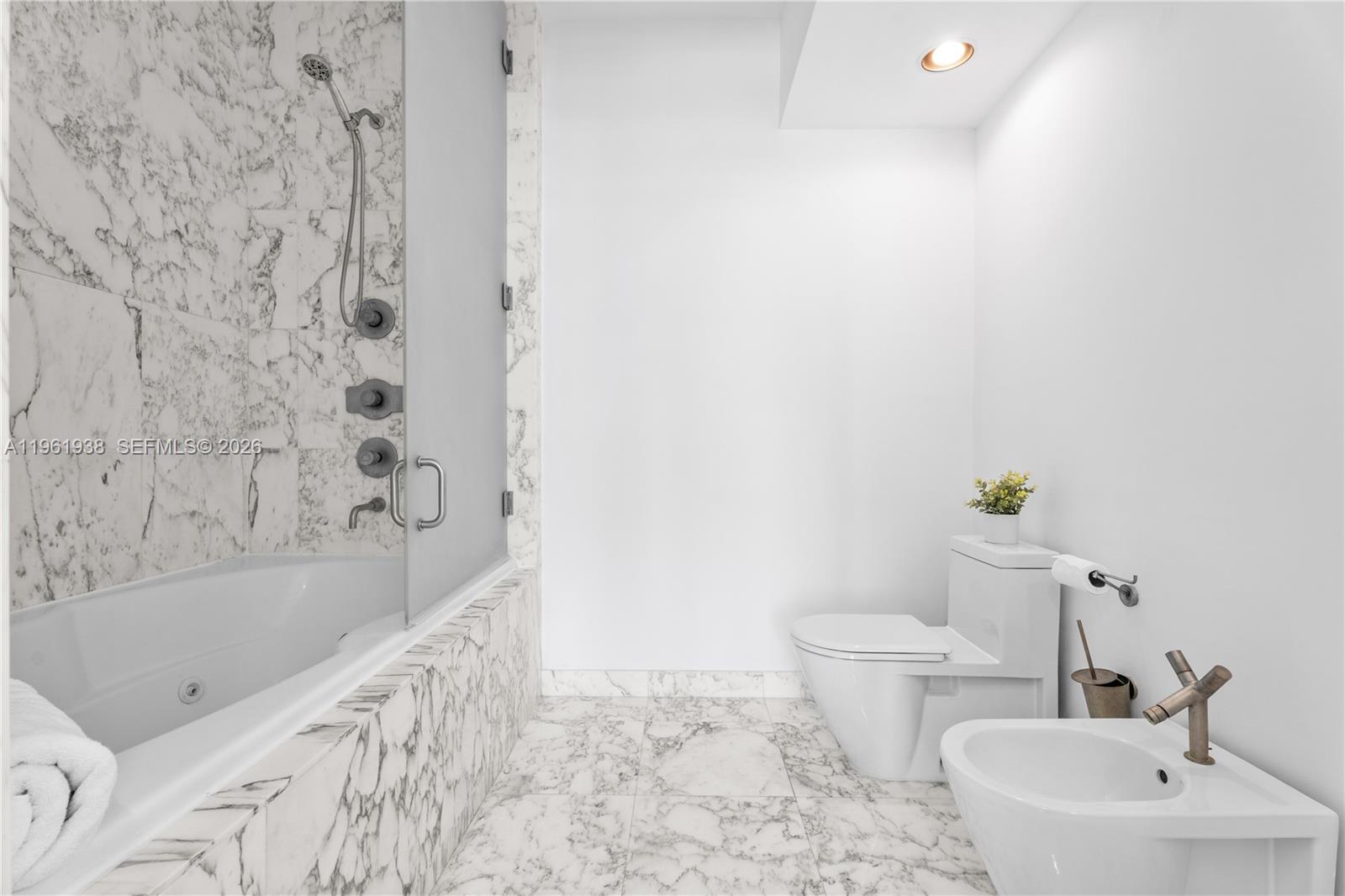 450 Alton Road, Unit 3008 Miami Beach, FL 33139 - Photo 11 of 34 a bathroom with a bathtub sink and toilet