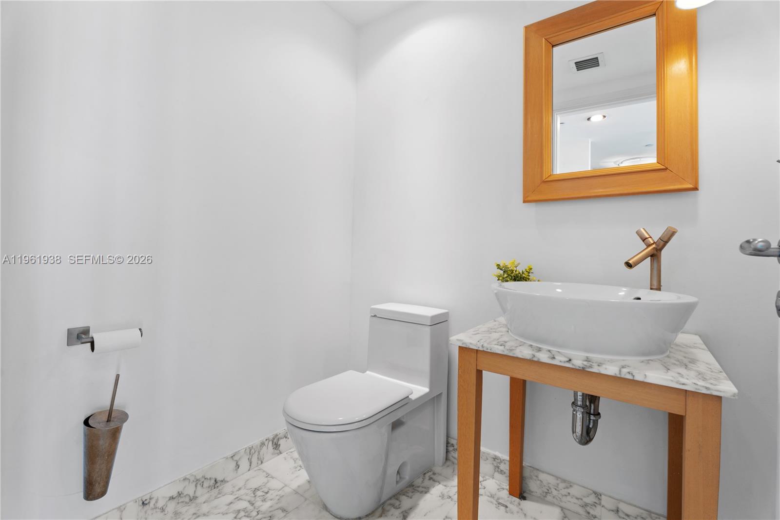 450 Alton Road, Unit 3008 Miami Beach, FL 33139 - Photo 6 of 34 a bathroom with a sink and a toilet