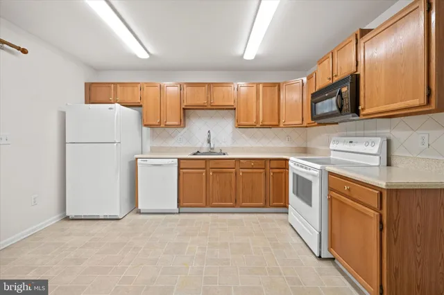 a kitchen with stainless steel appliances granite countertop a stove a sink dishwasher and a refrigerator