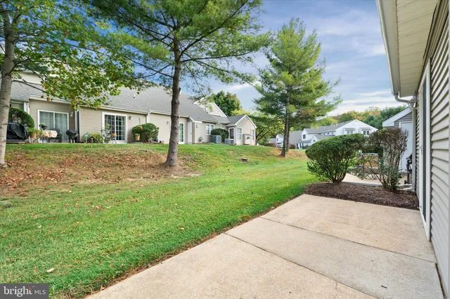 a front view of a house with a yard and trees