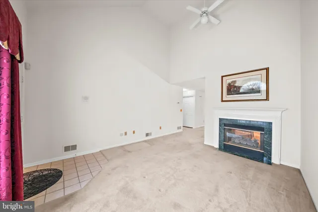 an empty room with windows and fireplace