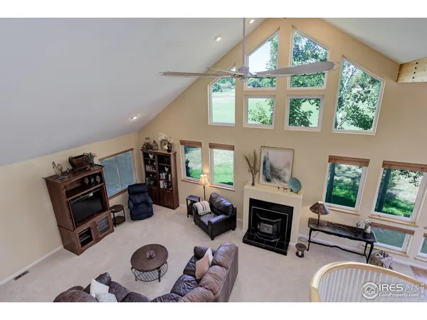 a living room with furniture a fireplace and a large window