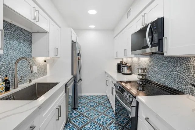 a kitchen that has a sink and a stove top oven