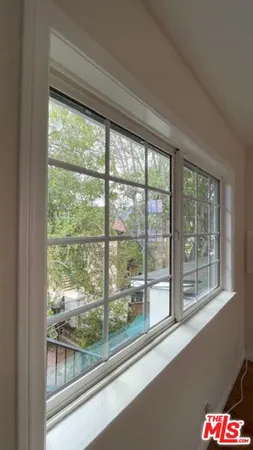 a view of a glass door and a car parked from a window