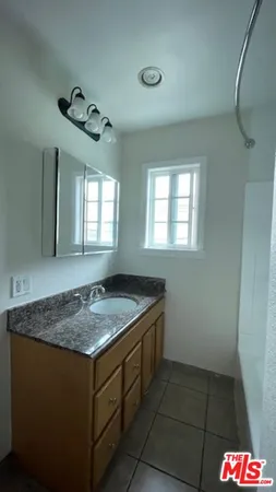 a bathroom with a granite countertop sink and a mirror