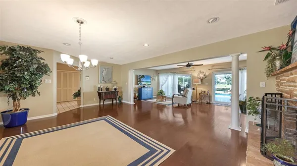 a kitchen with stainless steel appliances a stove a sink dishwasher a dining table and chairs with wooden floor