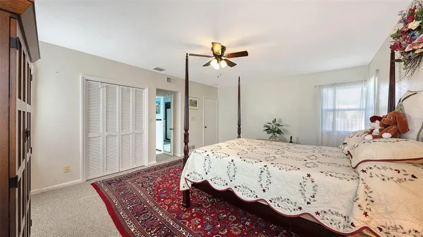 a bedroom with a bed potted plant with the mirror