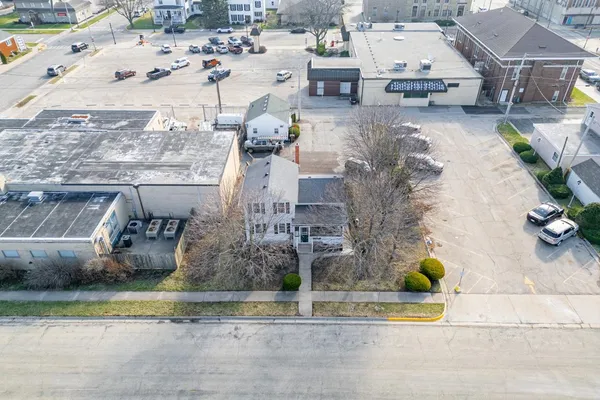 an aerial view of a house with a yard and big trees