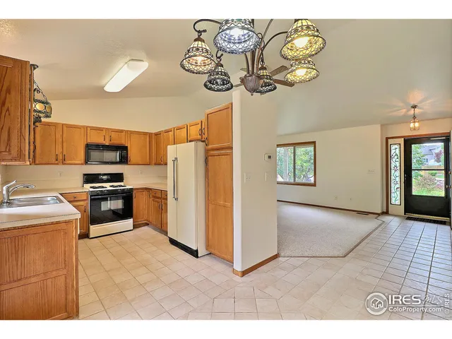 a kitchen with granite countertop a refrigerator and a sink