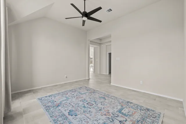 an empty room with a ceiling fan and wooden floor