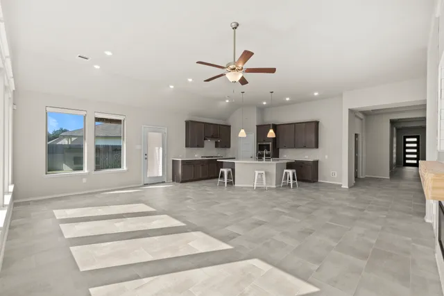 a view of a hallway with a ceiling fan and window