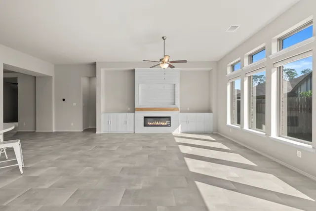 a view of a hallway with a ceiling fan and window