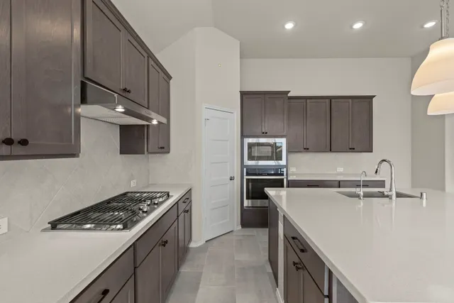 a kitchen with a sink stove and refrigerator