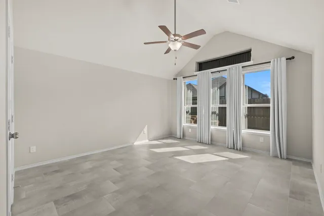 en empty room with windows and ceiling fan