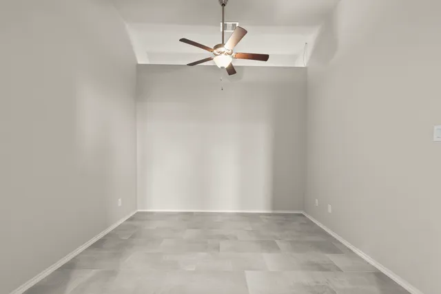 a view of a room with a ceiling fan and window
