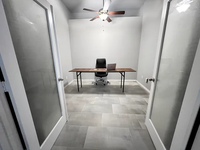 a view of a hallway with a table and chairs