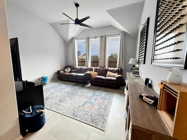 a living room with furniture floor to ceiling window and a flat screen tv