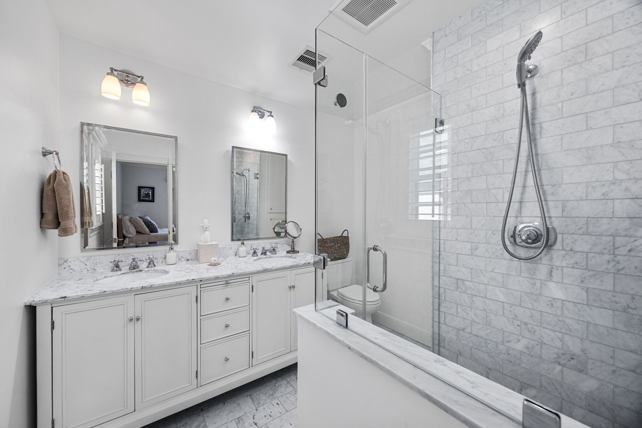 1741 Banks Street Houston, TX 77098 - Photo 30 of 50 a bathroom with a double vanity sink a toilet a mirror and shower