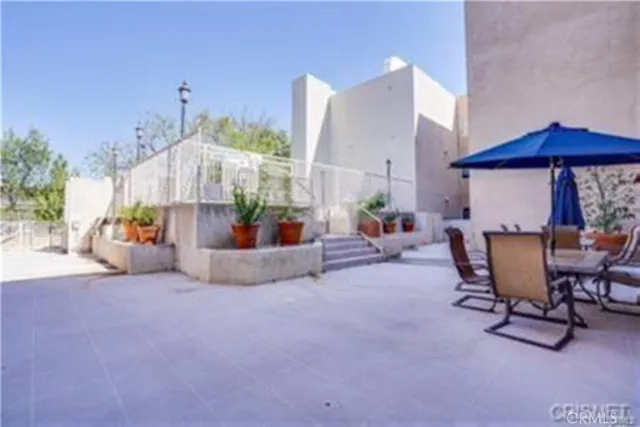 a view of a chairs and table in the back yard of the house