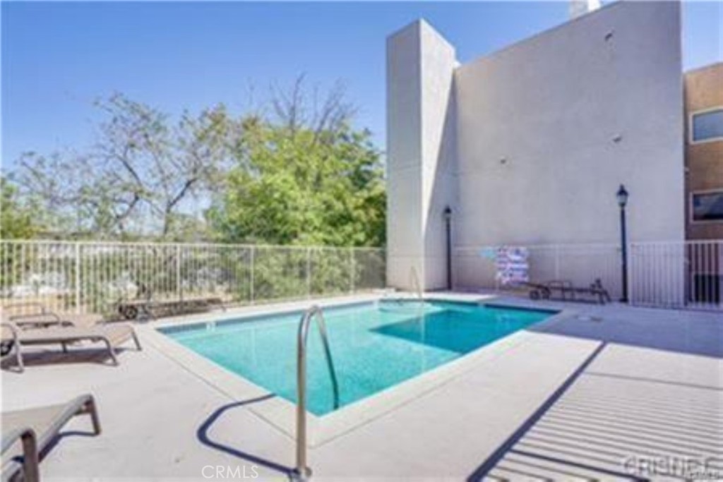 9610 Zelzah Avenue, Unit 310 Northridge, CA 91325 - Photo 23 of 32 a view of a swimming pool with a lounge chairs