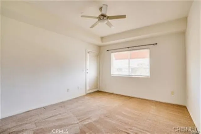 an empty room with a window and a ceiling fan