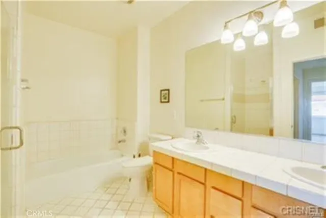 a bathroom with a granite countertop sink a mirror and a bathtub