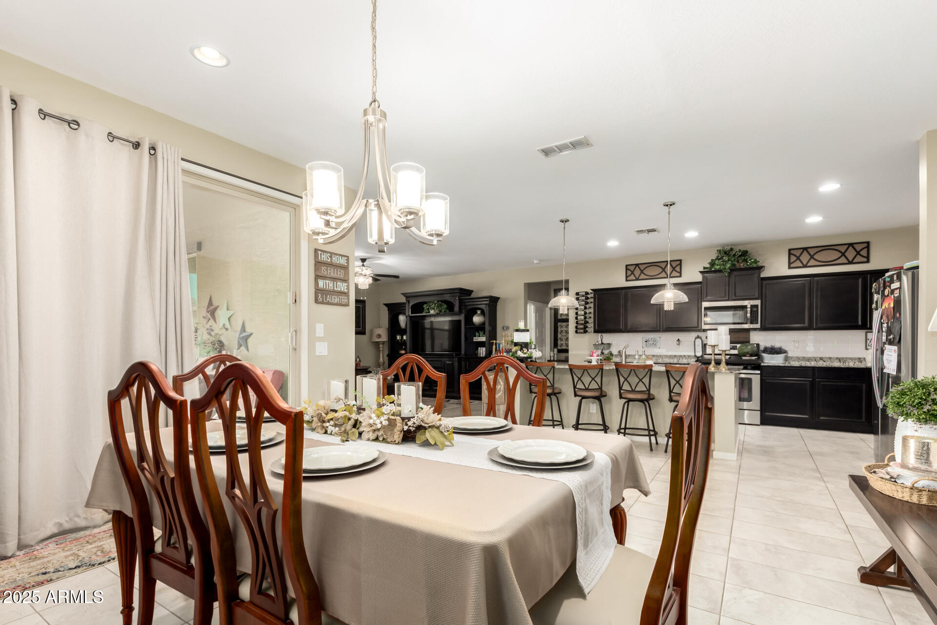 40098 West Ganly Way Maricopa, AZ 85138 - Photo 13 of 46 a view of a dining room and livingroom with furniture wooden floor a chandelier