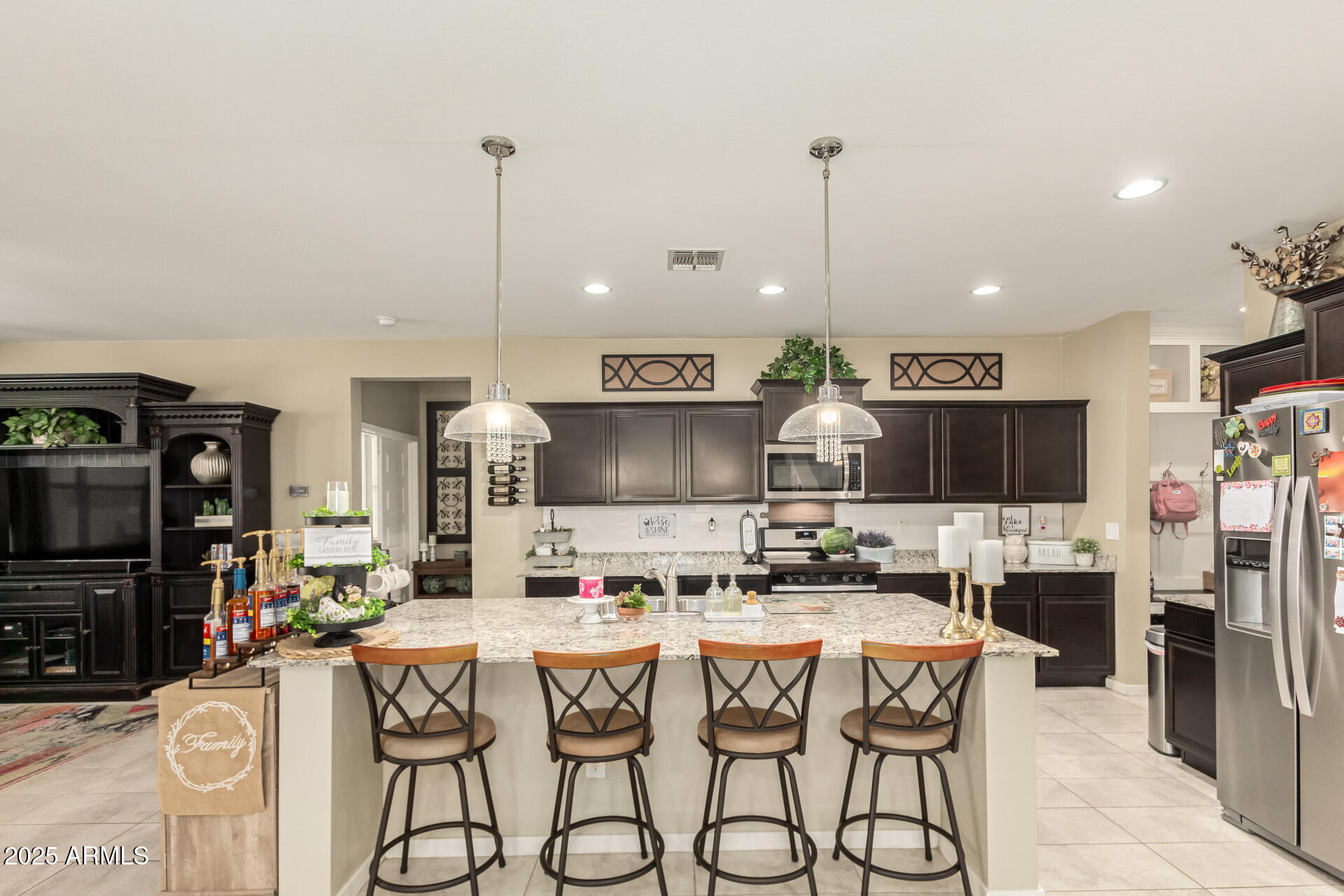 40098 West Ganly Way Maricopa, AZ 85138 - Photo 14 of 46 a kitchen with stainless steel appliances kitchen island granite countertop a refrigerator a stove a sink dishwasher and white cabinets with wooden floor