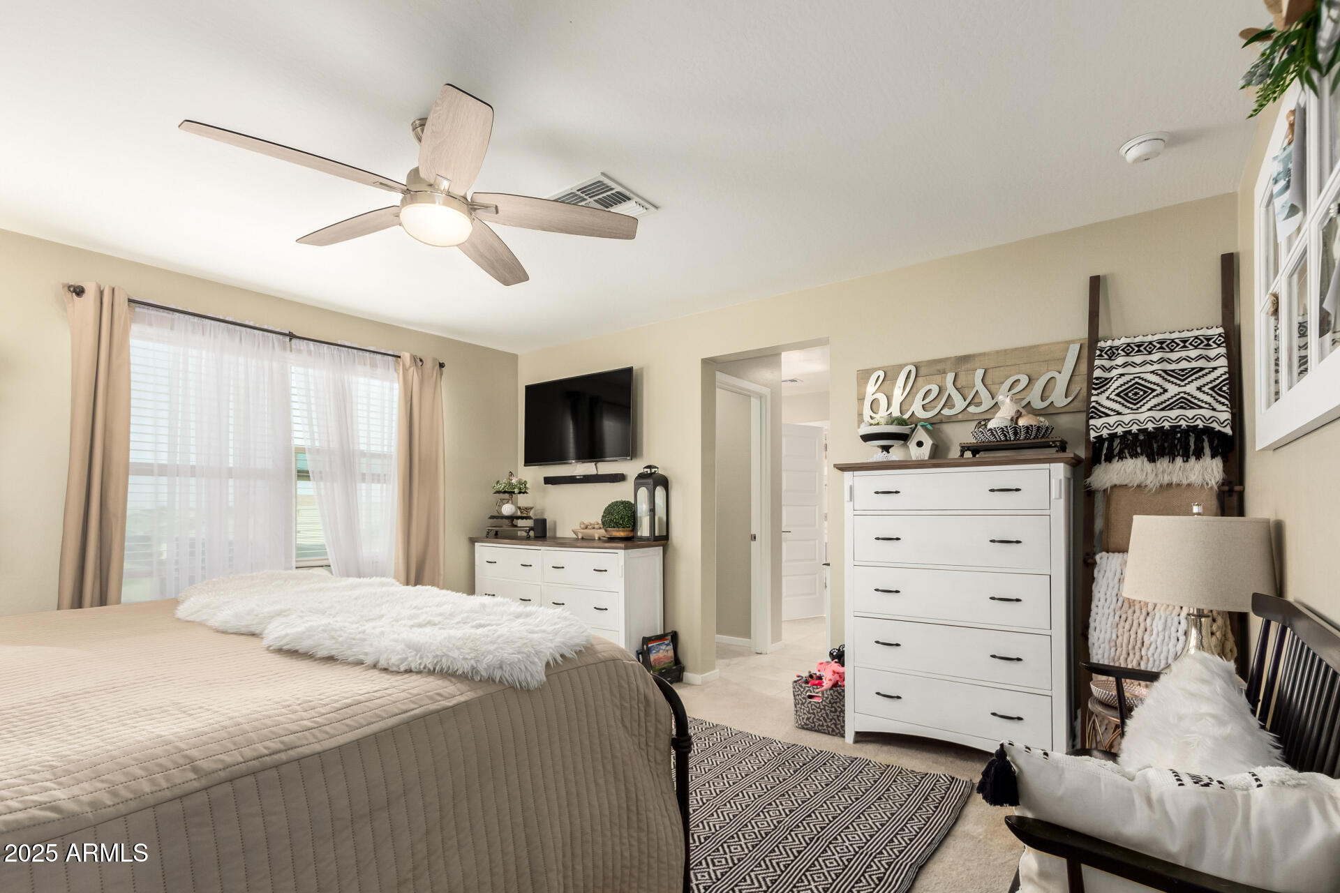 40098 West Ganly Way Maricopa, AZ 85138 - Photo 24 of 46 a bedroom with a bed a flat screen tv and a chandelier