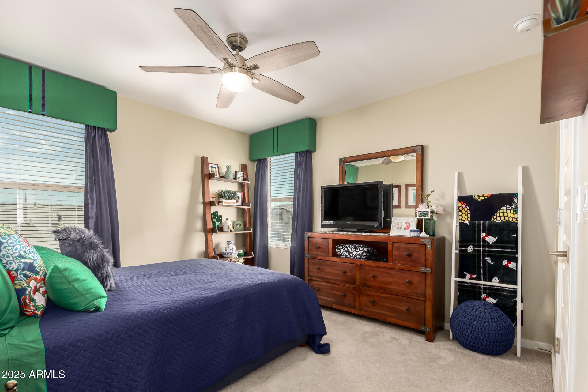 40098 West Ganly Way Maricopa, AZ 85138 - Photo 31 of 46 a bedroom with a bed a flat screen tv and a chandelier