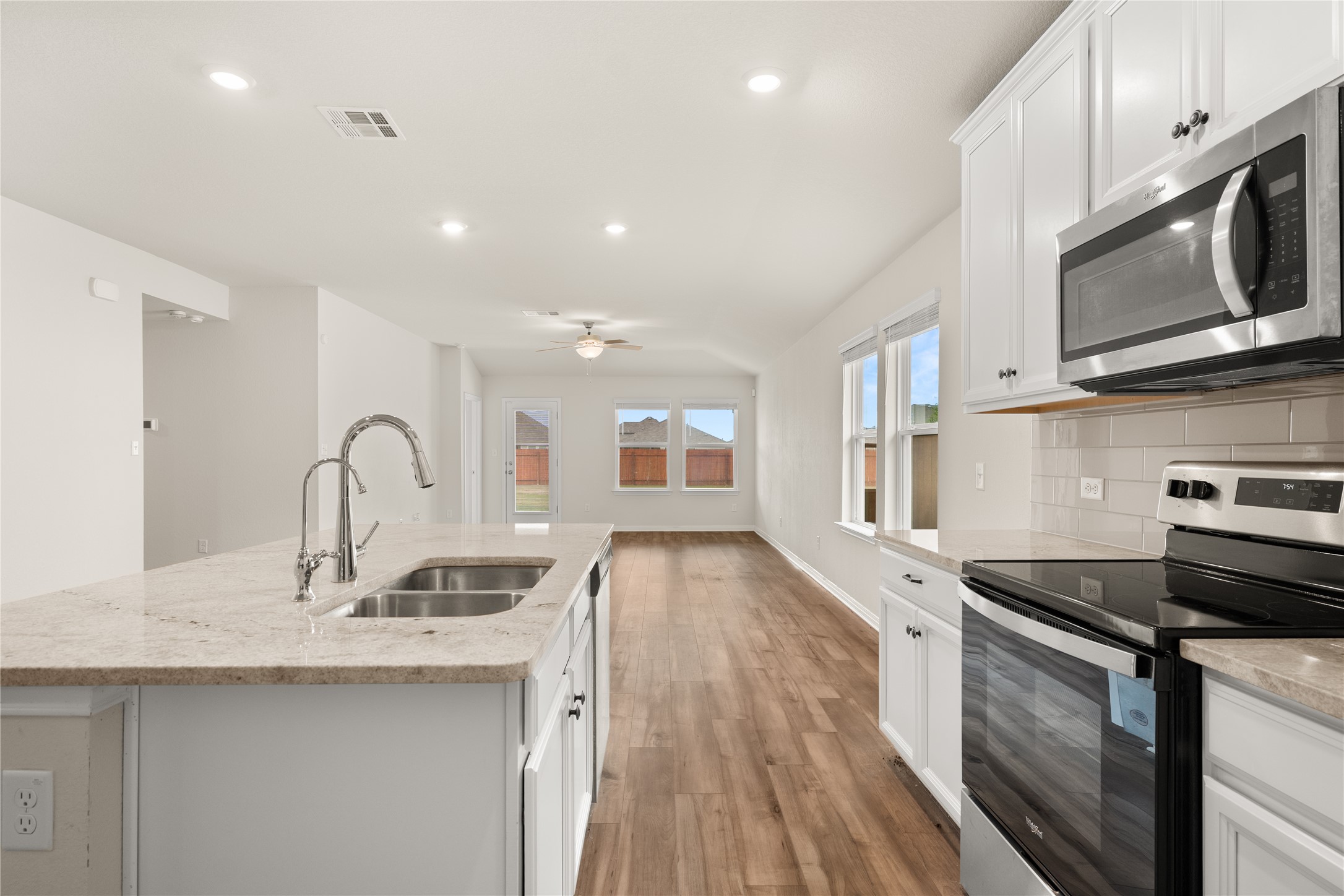 105 Saviano Road Hutto, TX 78634 - Photo 6 of 22 A well-appointed kitchen island with gleaming counters anchors an open-concept living space.