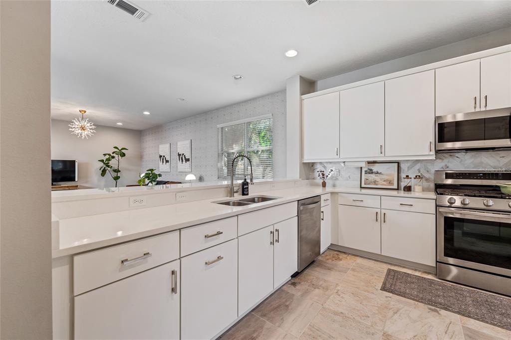 7935 Winter Wren Street Winter Garden, FL 34787 - Photo 13 of 36 a kitchen with sink cabinets and appliances