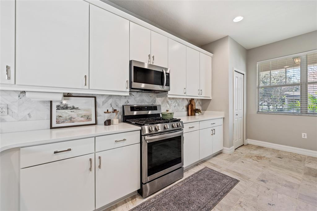 7935 Winter Wren Street Winter Garden, FL 34787 - Photo 14 of 36 a kitchen with granite countertop white cabinets and stainless steel appliances