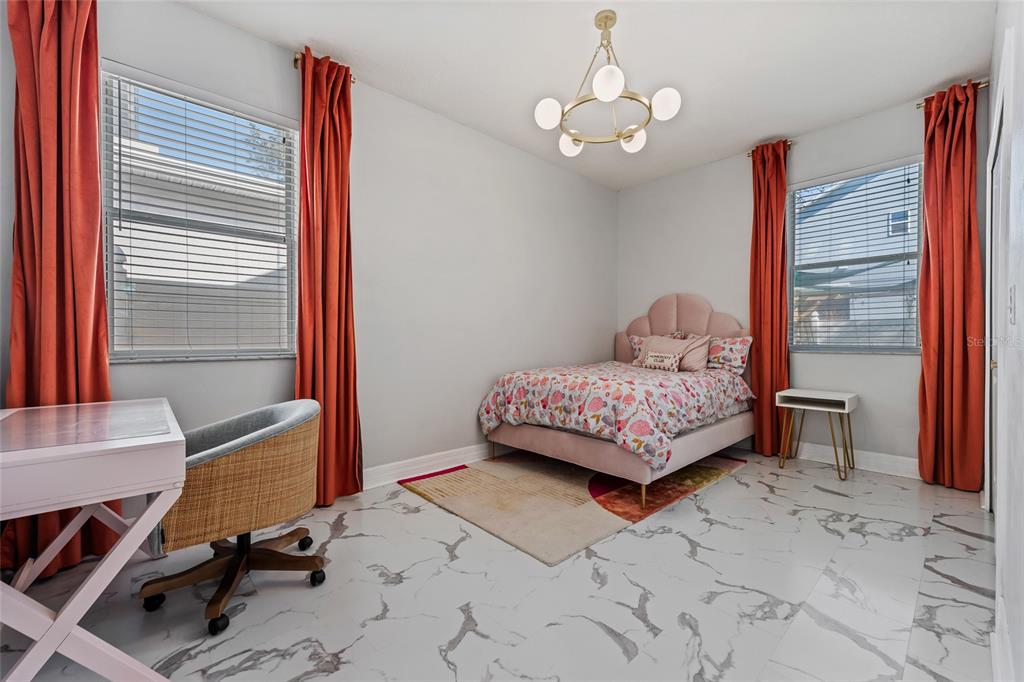 7935 Winter Wren Street Winter Garden, FL 34787 - Photo 22 of 36 a bedroom with a large bed and a window