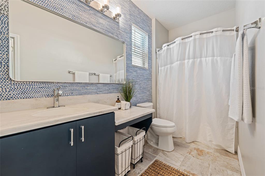 7935 Winter Wren Street Winter Garden, FL 34787 - Photo 23 of 36 a bathroom with a sink a toilet a mirror and shower curtain