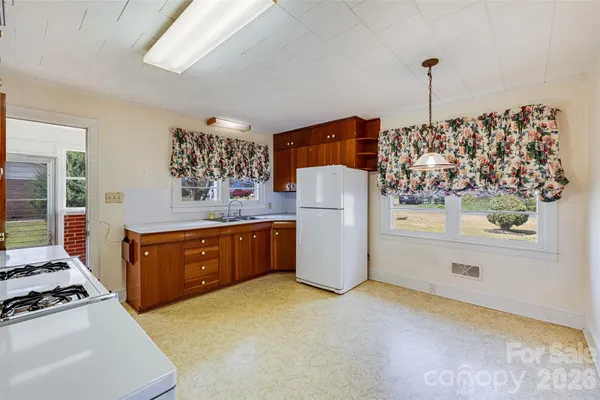 a kitchen with stainless steel appliances granite countertop a refrigerator a stove and a wooden floors