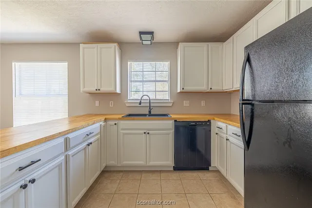a kitchen with a refrigerator sink and cabinets