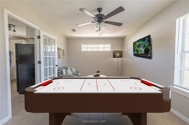 a room with pool table and windows